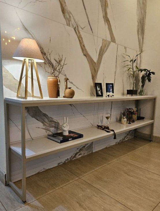Aparador de metal dourado com prateleiras, em ambiente decorado