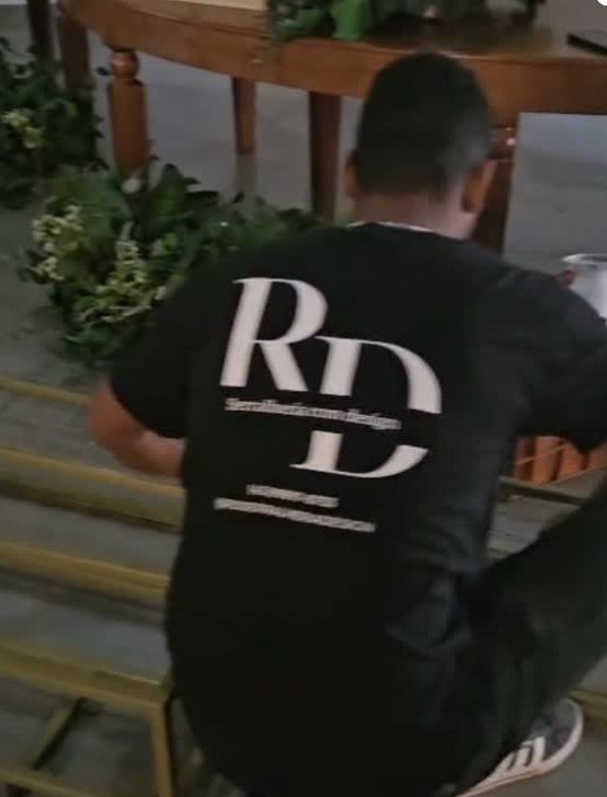 Profissional da RD Serralheria instalando uma peça, com a camisa da marca