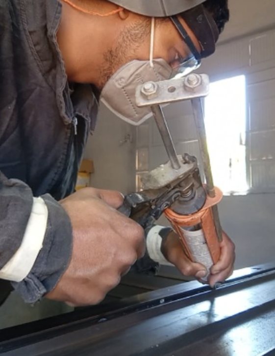 Corte de perfil metálico com esmerilhadeira na oficina