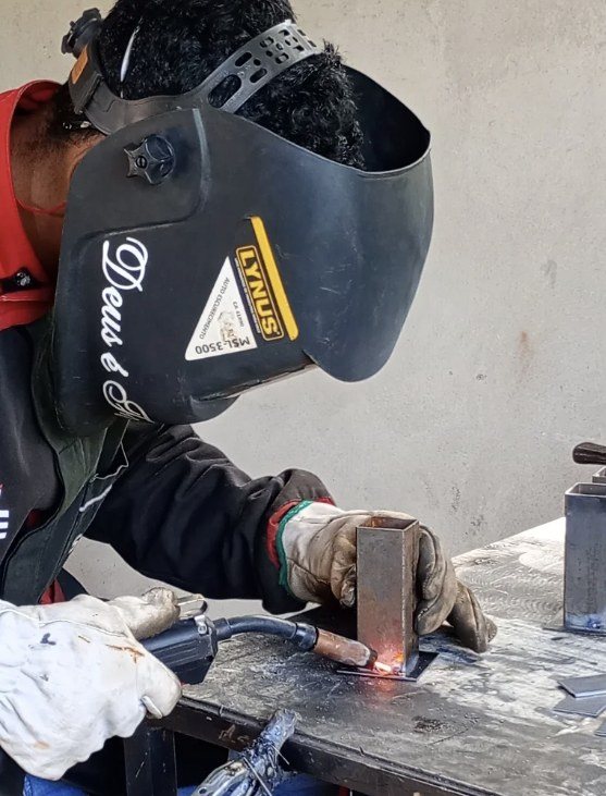 Soldador da RD trabalhando com máscara e luvas de proteção